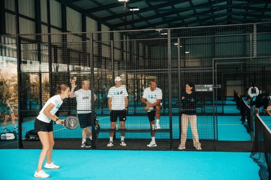 Players and coach on a blue club court during a session
